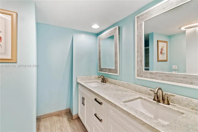 a bathroom with double vanity sinks and a mirror