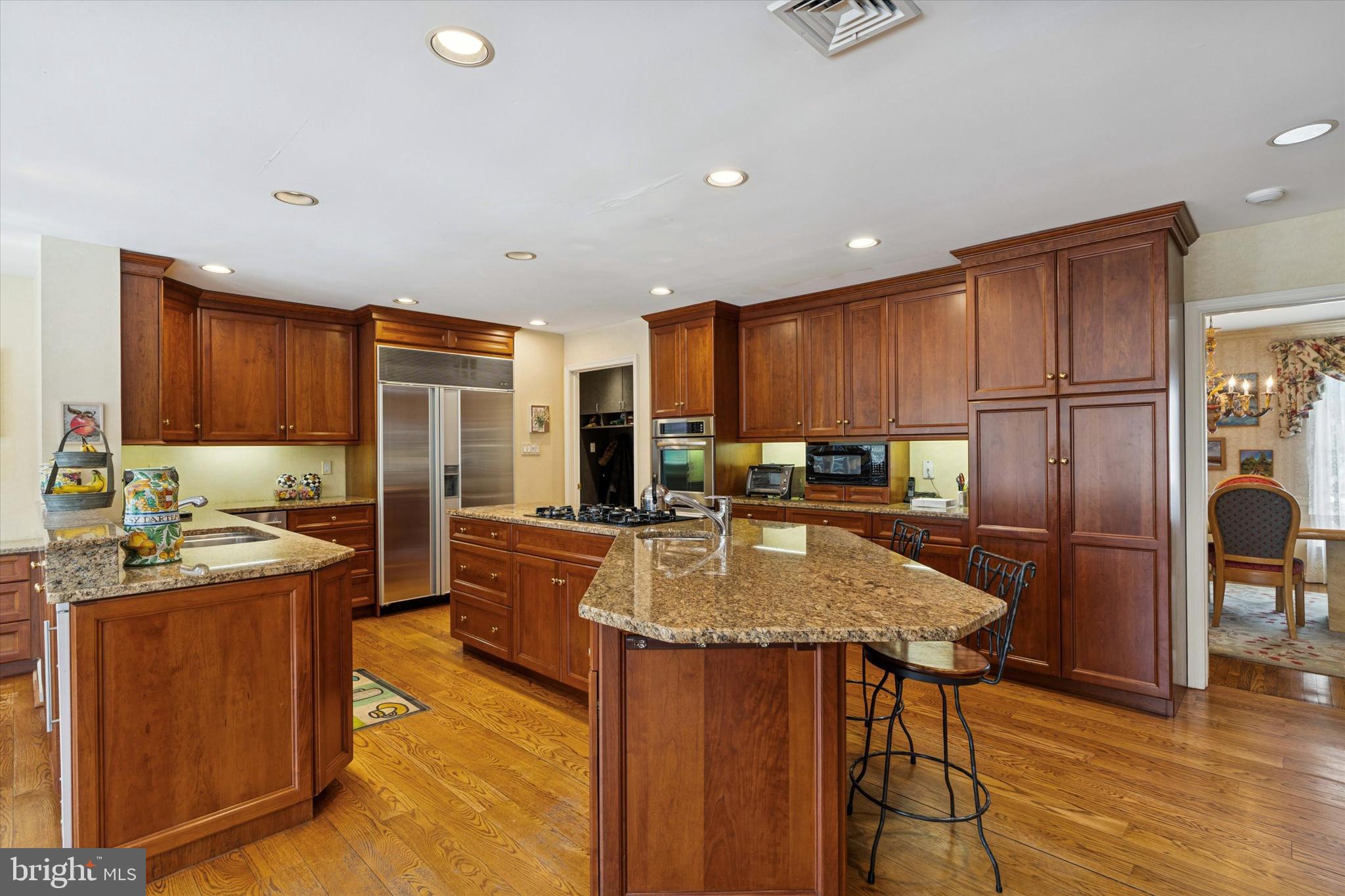 736 Woodleave Road Bryn Mawr, PA 19010 - Photo 13 of 44 a kitchen with refrigerator a stove and wooden cabinets with wooden floor