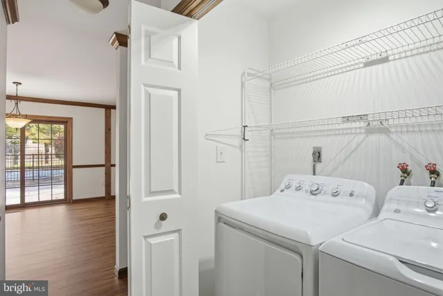 a view of washer and dryer with bathroom in the background