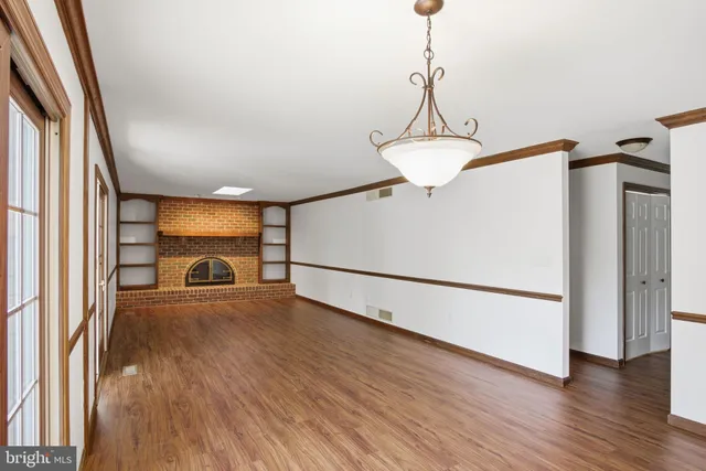 a view of a room with wooden floor and a ceiling fan