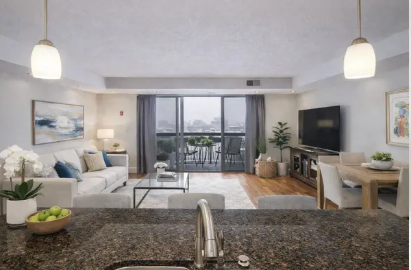 a living room with furniture a flat screen tv and a large window