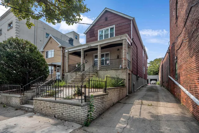 a view of house with a small yard and wooden fence