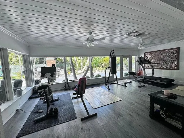 a living room with furniture gym equipment and a large window