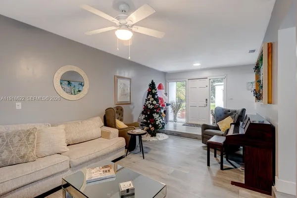 a living room with furniture and a wooden floor