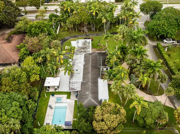 an aerial view of residential houses with outdoor space and trees