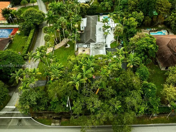 an aerial view of residential house with green space and mountain view in back