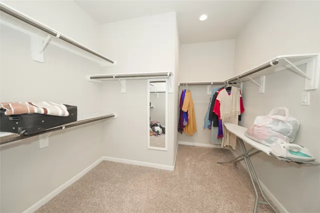 a view of walk in closet with clothes and shoes