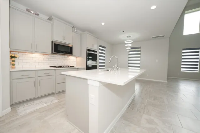 a kitchen with stainless steel appliances granite countertop a refrigerator and a sink