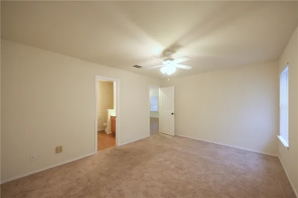 a view of an empty room with a chandelier fan