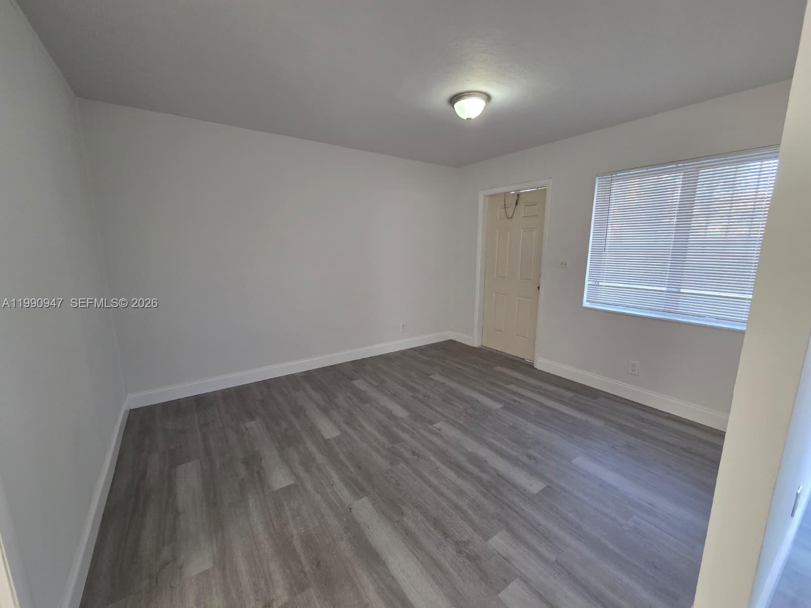 1628 Southwest 7th Street, Unit 4 Miami, FL 33135 - Photo 2 of 6 an empty room with wooden floor and windows
