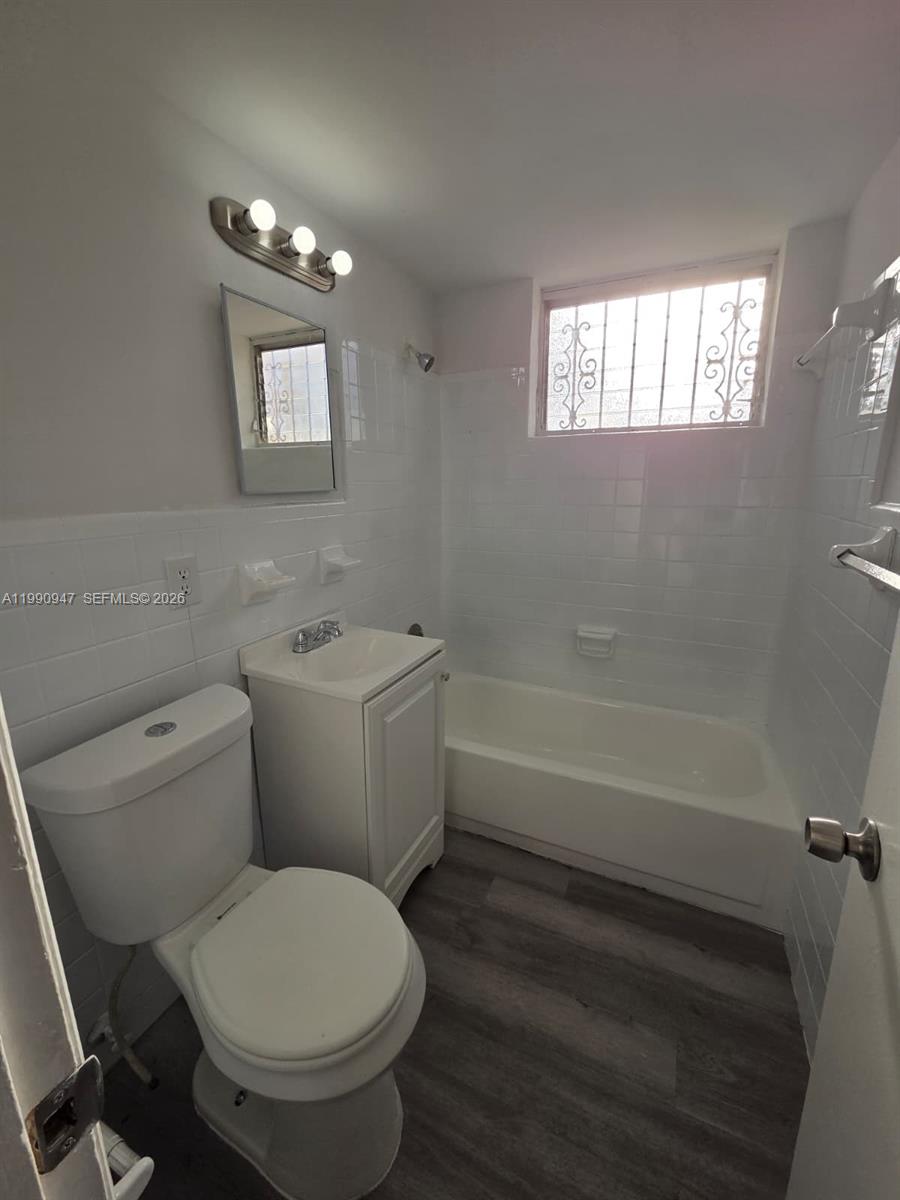 1628 Southwest 7th Street, Unit 4 Miami, FL 33135 - Photo 5 of 6 a white toilet sitting next to a bath tub
