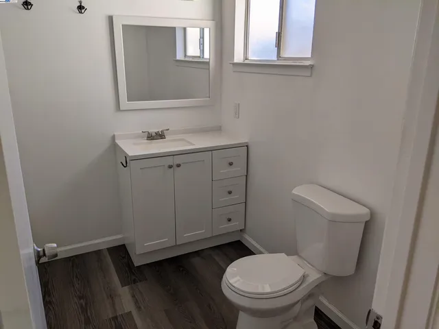 a bathroom with a granite countertop toilet and a sink