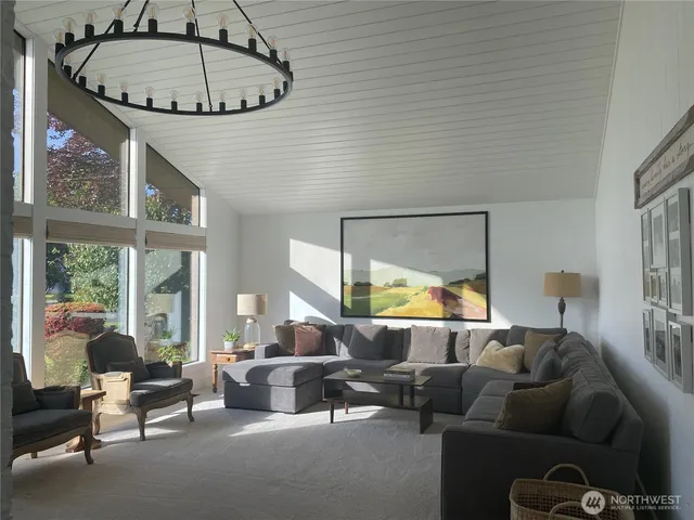 a living room with furniture a fireplace and a large window