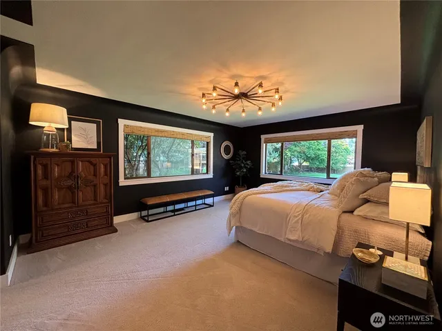 a bed sitting in a bedroom next to a window