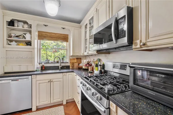 a kitchen with stainless steel appliances granite countertop a stove and a microwave