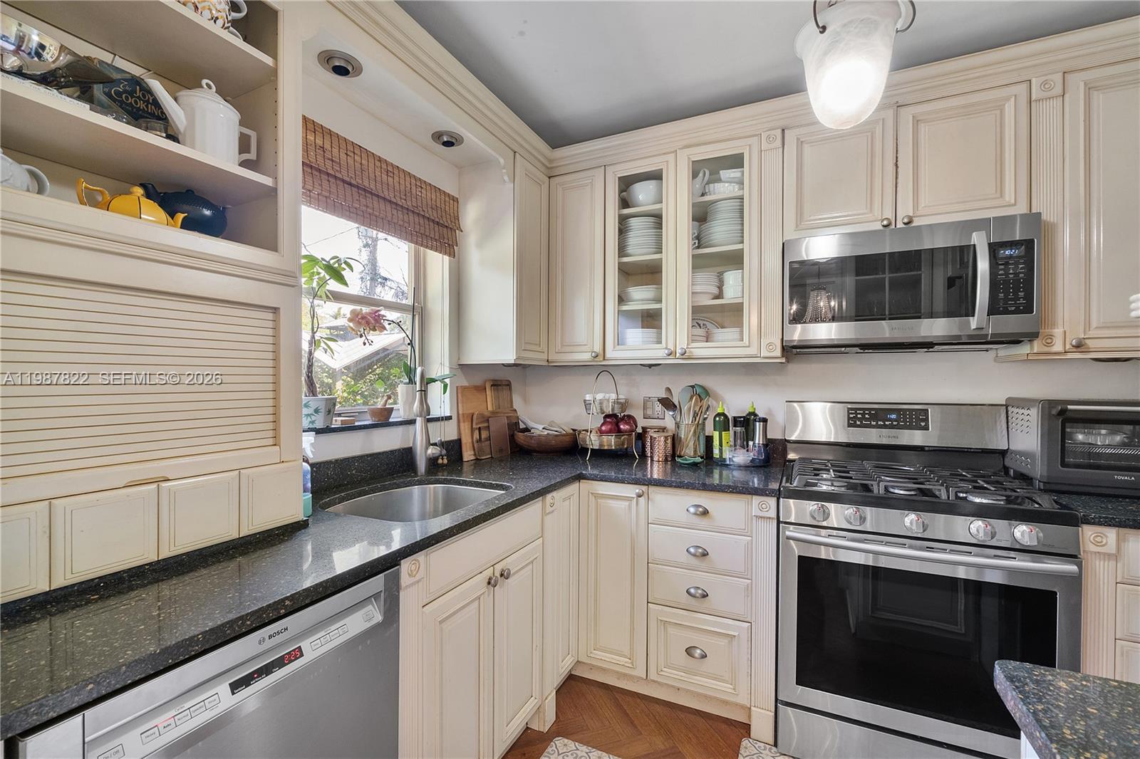 5961 Southwest 46th Terrace Miami, FL 33155 - Photo 12 of 28 a kitchen with granite countertop white cabinets stainless steel appliances a sink and a window