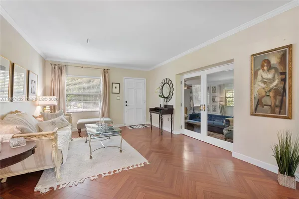 a living room with furniture large window and wooden floor
