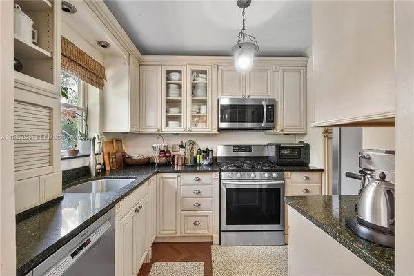 a kitchen with stainless steel appliances granite countertop a stove sink microwave and refrigerator