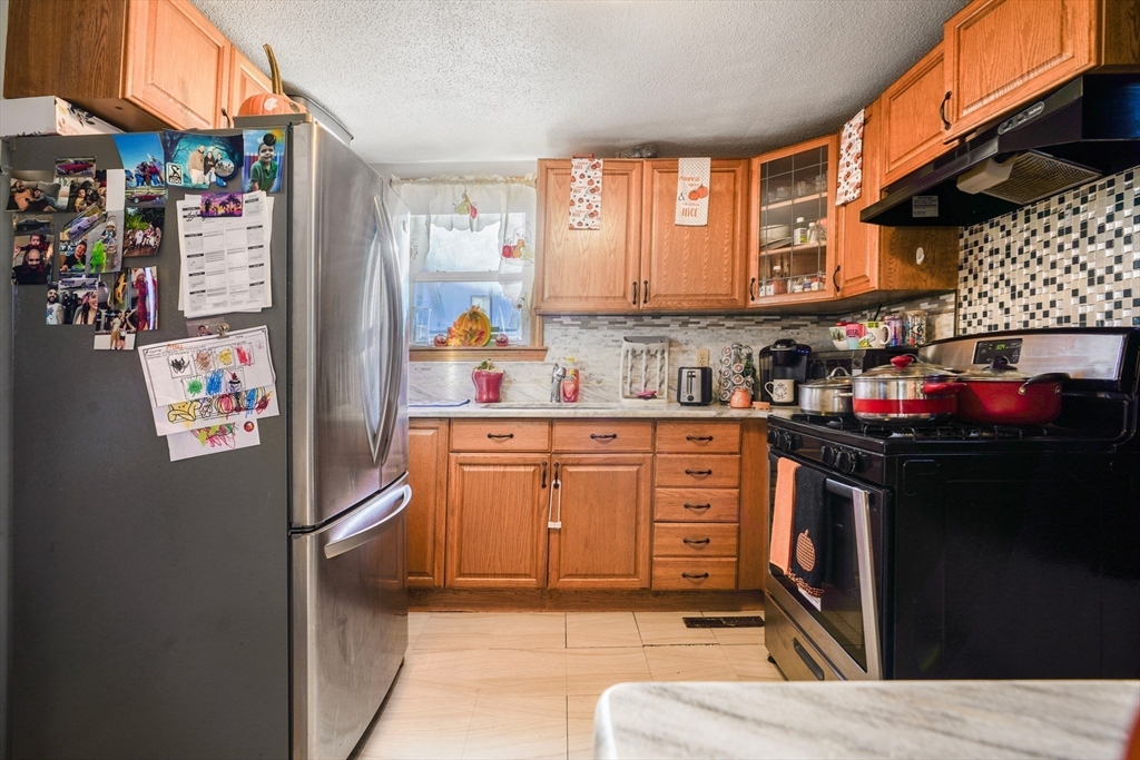 45 Boutwell Street Fall River, MA 02723 - Photo 9 of 36 a kitchen with stainless steel appliances granite countertop a stove a sink and a refrigerator