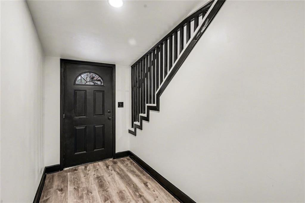 166 Evans Road Griffin, GA 30223 - Photo 13 of 36 a view of hallway with stairs and wooden floor