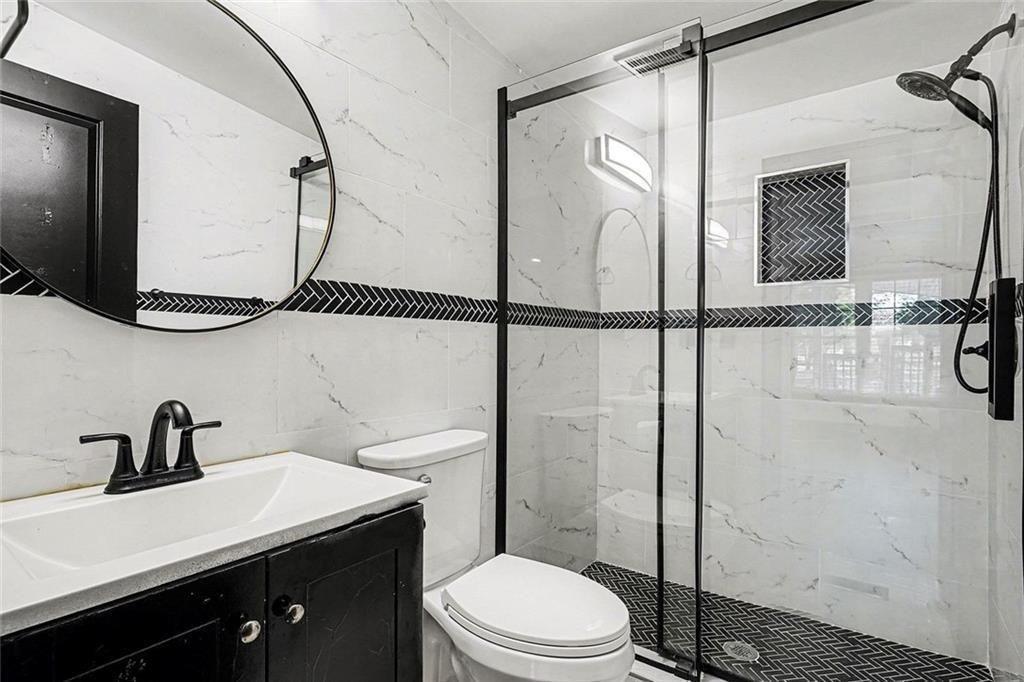 166 Evans Road Griffin, GA 30223 - Photo 23 of 36 a bathroom with a sink a mirror a toilet and shower