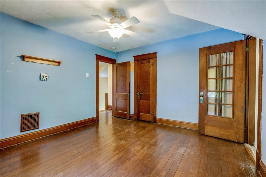 176 Churchill Road Turtle Creek, PA 15145 - Photo 22 of 25 Bedroom 3 with original hardwood floor and details and glass door to the captive extra room.