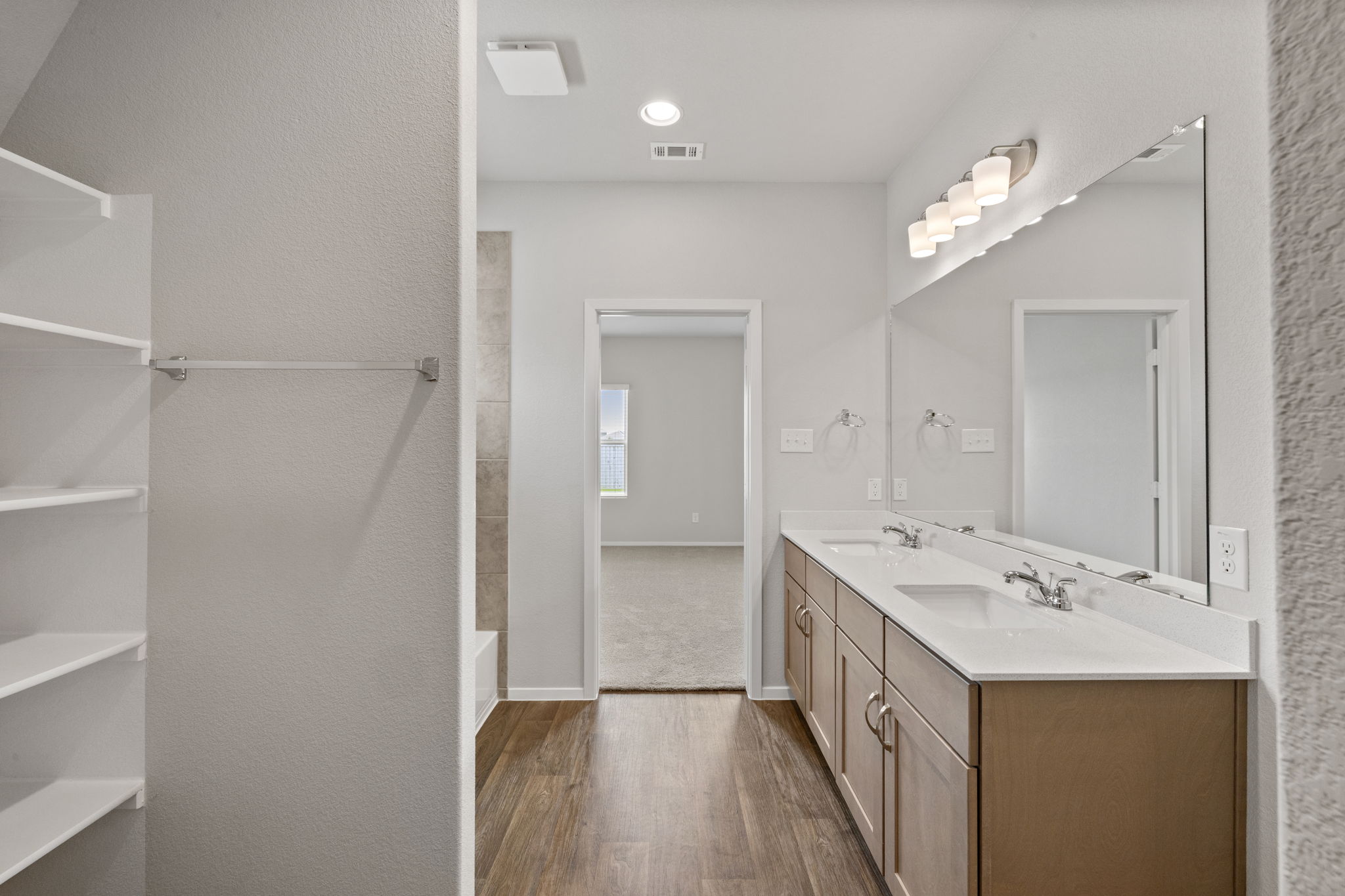2460 Winding Creek Road Kyle, TX 78640 - Photo 13 of 20 Double vanity and spacious shower create a serene, well-appointed primary bath.