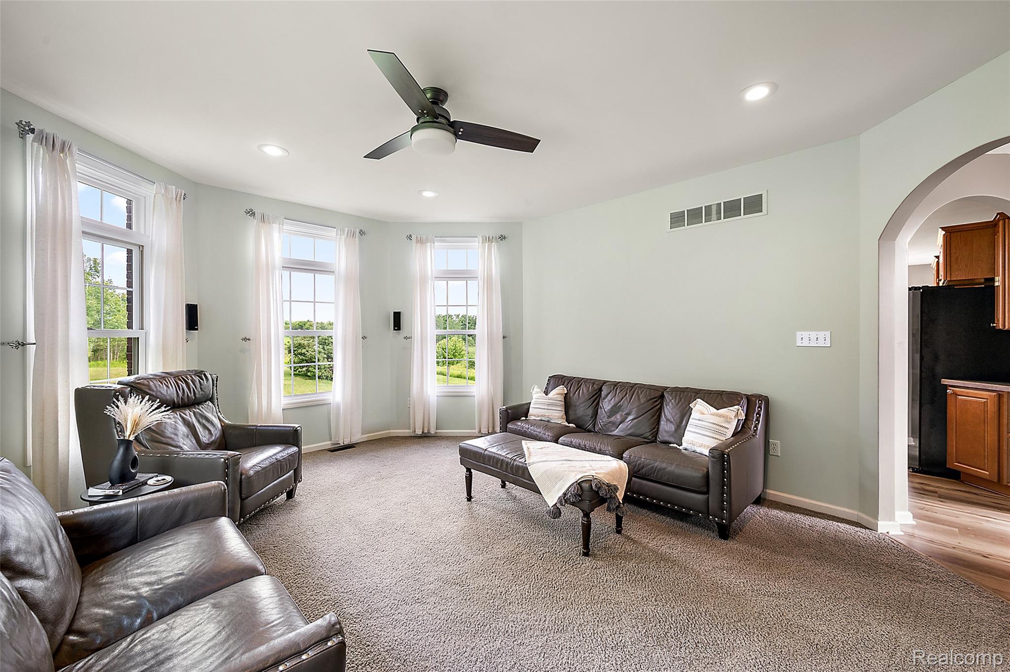 5035 Hidden Ridge Road Metamora, MI 48455 - Photo 10 of 65 Living area featuring a curved wall with three large windows, recessed lighting, and a ceiling fan