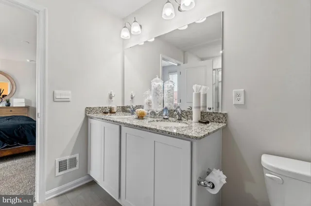 a bathroom with a granite countertop sink and a mirror