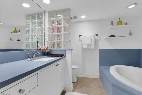 a bathroom with a granite countertop sink a toilet and shower