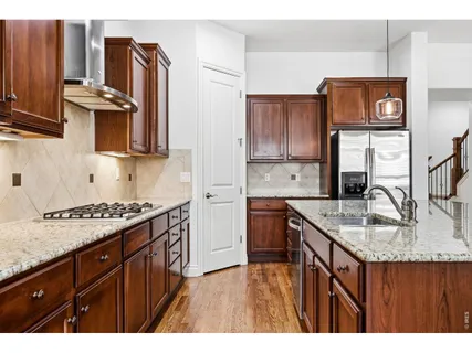 a kitchen with stainless steel appliances granite countertop a sink stove and refrigerator