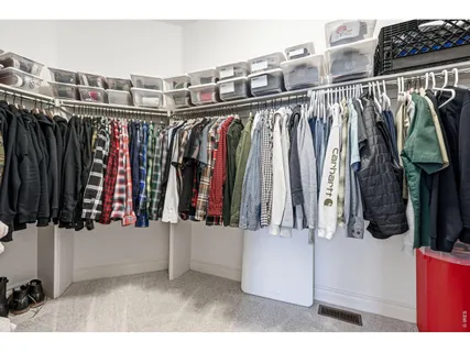 a view of walk in closet with clothes and shoes