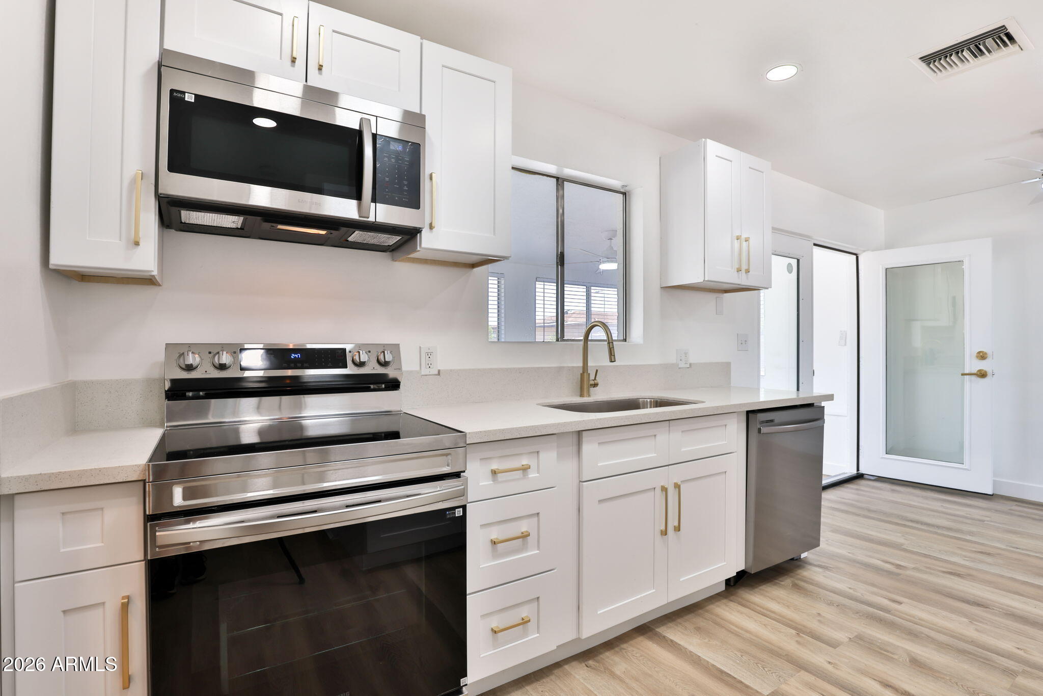 5510 East Dallas Street Mesa, AZ 85205 - Photo 9 of 24 a kitchen with stainless steel appliances granite countertop a stove a sink and a microwave