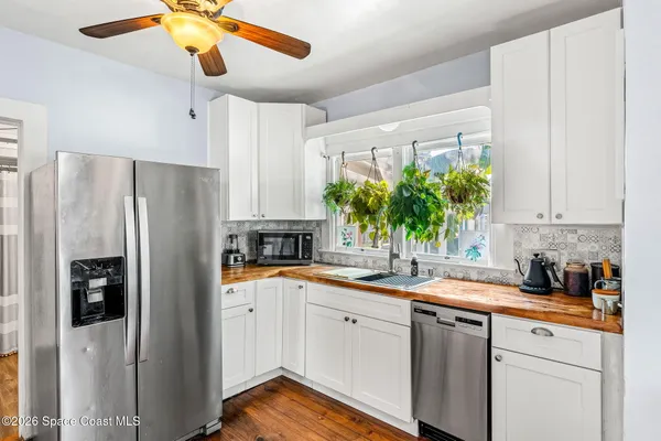 a kitchen with stainless steel appliances a stove a sink a refrigerator and wooden floor