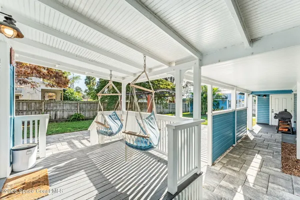 a view of a house with wooden deck and furniture