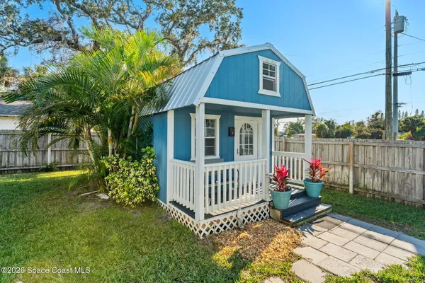 a view of a house with a yard and a tree