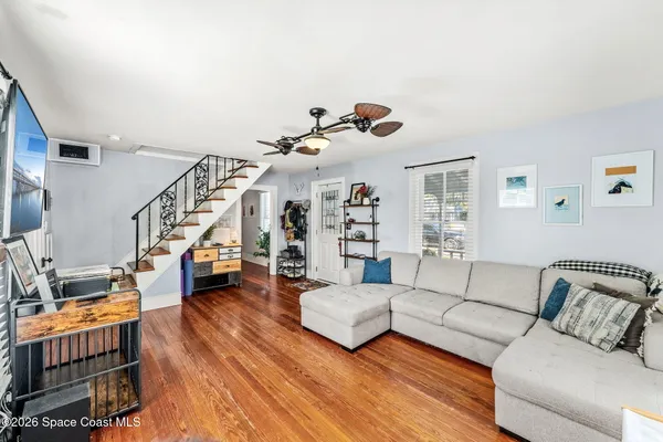 a living room with furniture and wooden floor