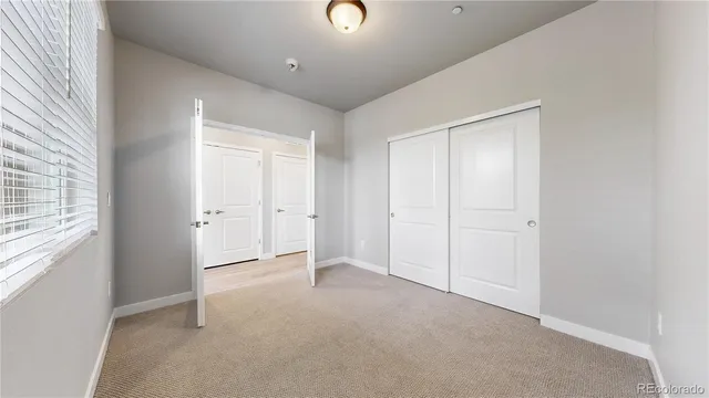 an empty room with windows and closet