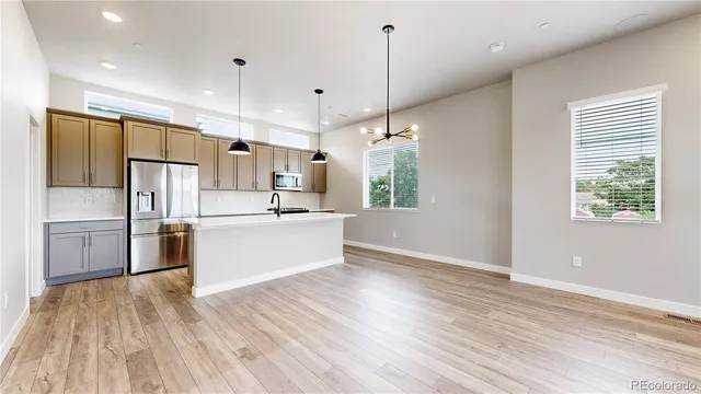 a large kitchen with cabinets wooden floor and stainless steel appliances