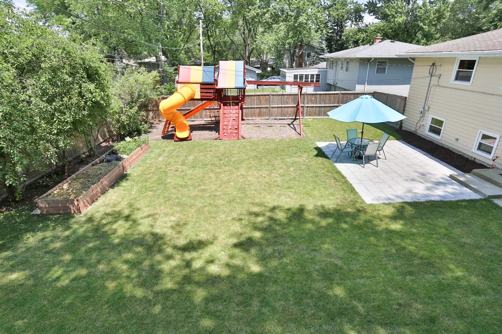 413 West Gartner Road Naperville, IL 60540 - Photo 21 of 22 a backyard of a house with table and chairs under an umbrella