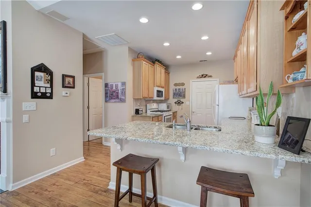 a kitchen with stainless steel appliances granite countertop a sink and a refrigerator