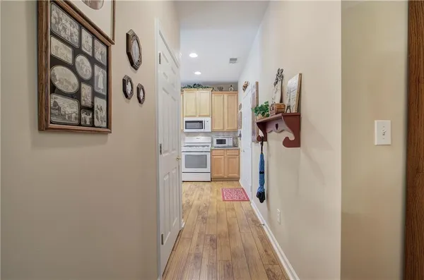 a view of a hallway with wooden floor and closet