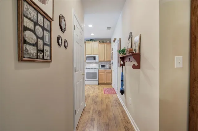 a view of a hallway with wooden floor and closet