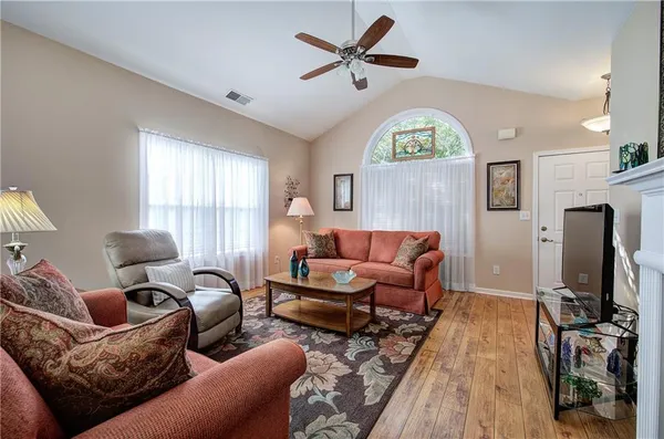 a living room with furniture a window and a flat screen tv