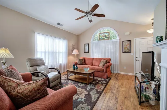 a living room with furniture a window and a flat screen tv