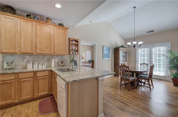 a kitchen with a table chairs and white cabinets