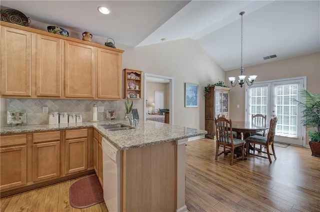 a kitchen with a table chairs and white cabinets