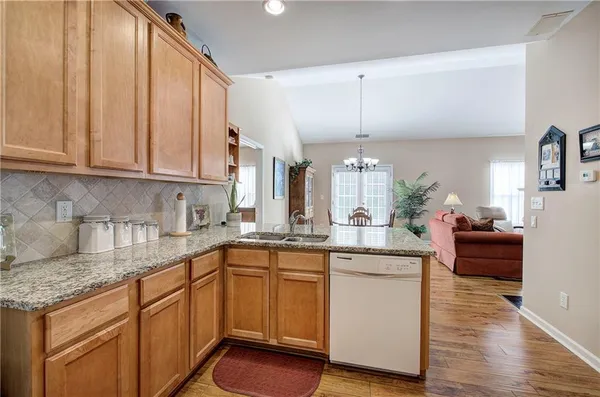 a kitchen with a sink cabinets and wooden floor