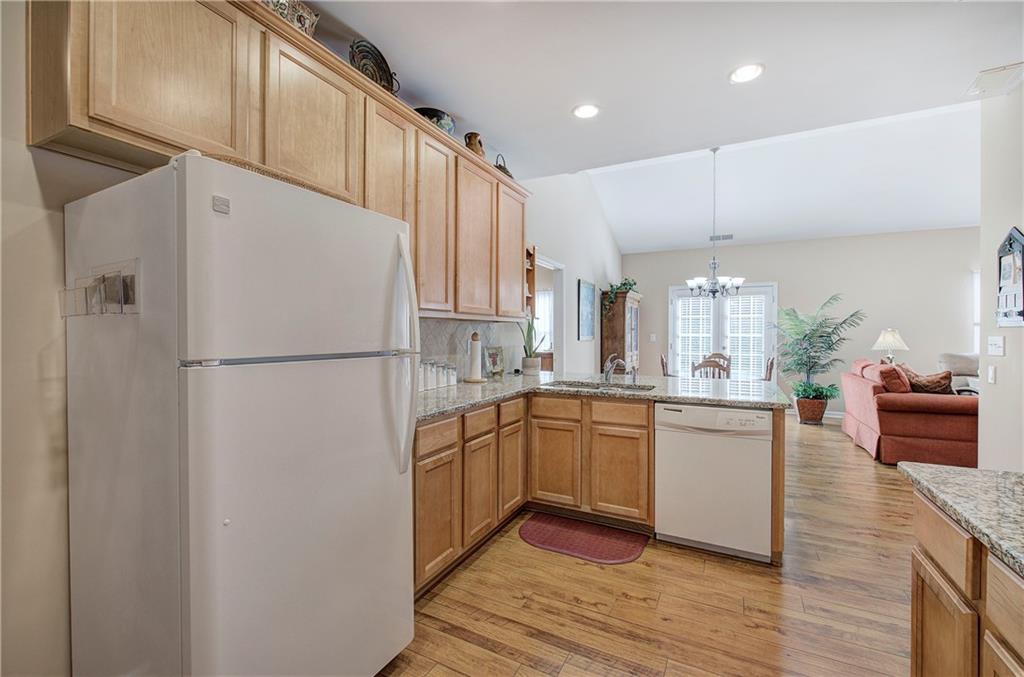 3383 Raes Creek Road, Unit 4 Marietta, GA 30008 - Photo 35 of 41 a kitchen with stainless steel appliances granite countertop a refrigerator a sink dishwasher a stove and white cabinets with wooden floor
