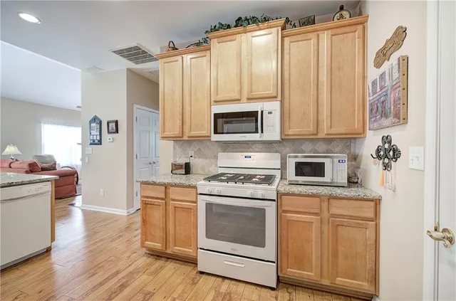 a kitchen with white cabinets and white appliances